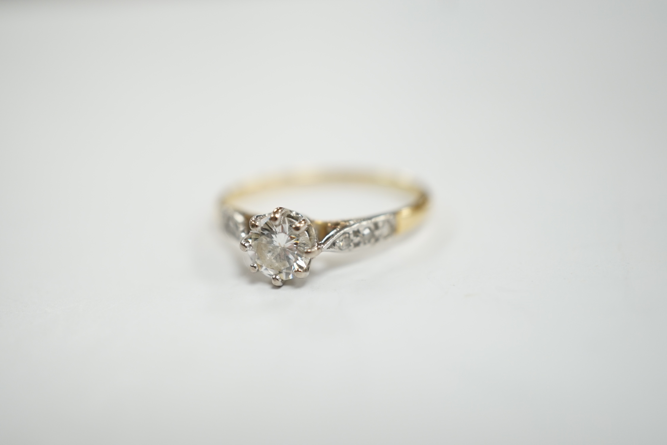 An 18ct and single stone diamond set ring, with diamond chip set shoulders, size M, gross weight 1.9 grams.